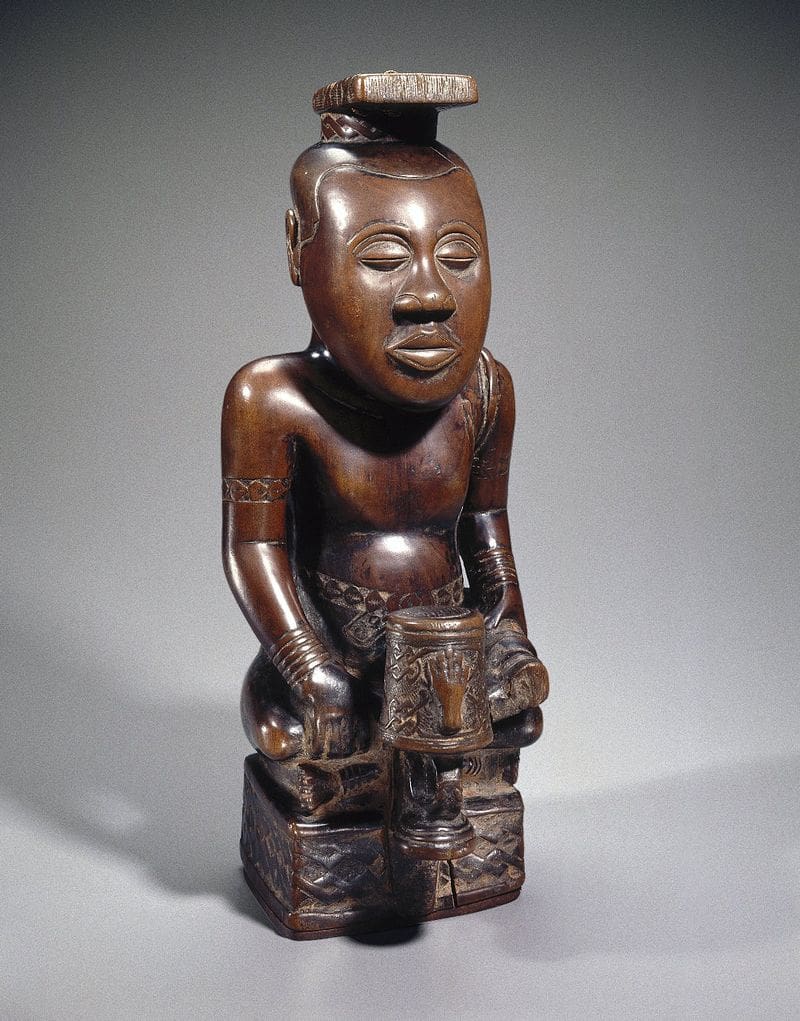 A statue of a man sitting on a table.